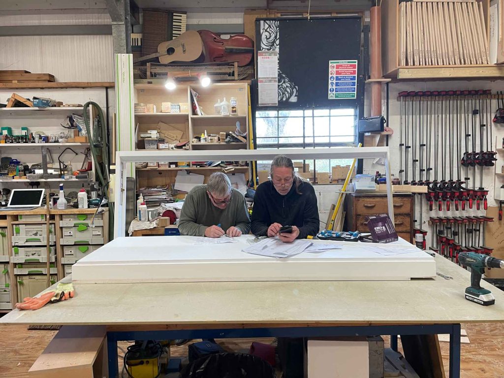 Two of our craftsmen reviewing drawings in our workshop