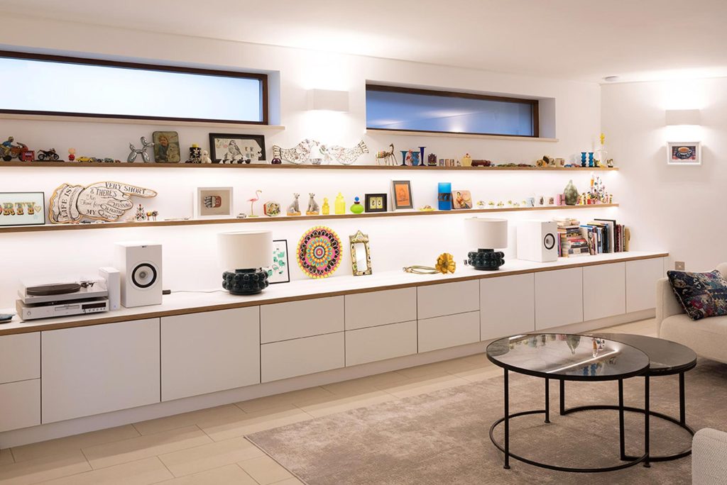 A modern shelving unit displaying various decorative items in a living room setting.